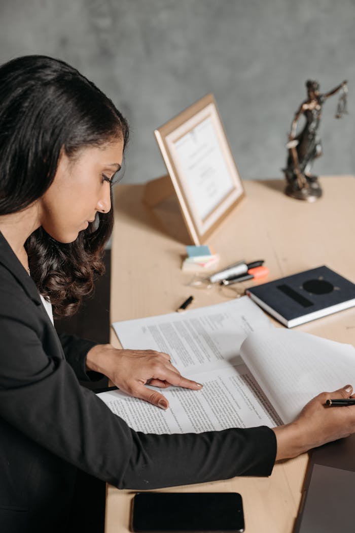 Businesswoman in an office reviewing documents with concentration and focus.